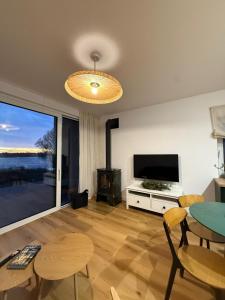 ein Wohnzimmer mit Fernseher und Tisch und Stühlen in der Unterkunft SEN TOPOLI Domy nad jeziorem 