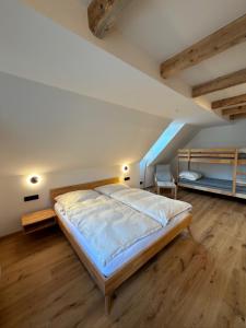 een slaapkamer met een bed en 2 stapelbedden bij Das Detox Almhaus in Pusterwald