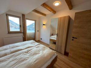 een slaapkamer met een bed en een deur met een spiegel bij Das Detox Almhaus in Pusterwald