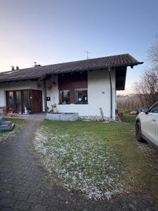 una casa con un'auto parcheggiata davanti di Ruhig gelegenes Ferienzimmer in Bodolz a Lindau-Bodolz