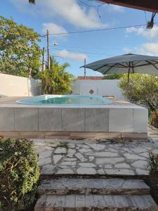 einen Pool mit Sonnenschirm im Hof in der Unterkunft Casa de Fagundes PB in Lucena