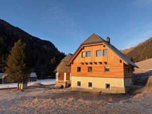 een groot houten huis bovenop een veld bij Das Detox Almhaus in Pusterwald