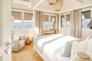 a bedroom with a white bed and windows at Boutique hôtel Château Rouher in Propriano