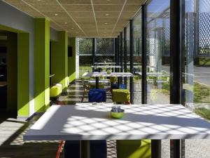 een cafetaria met tafels, stoelen en ramen bij ibis budget Albi Terssac in Terssac +23 foto's