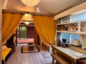 a living room with a table and yellow curtains at Faaora Lodge, little paradise Moorea in Haapiti +14 photos