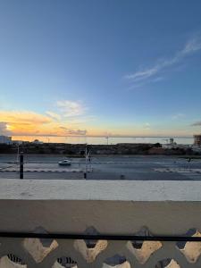 een uitzicht op een parkeerplaats met de zonsondergang op de achtergrond bij F3 Mostaganem vue sur la Mer in Mostaganem