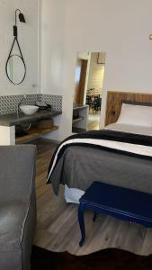 a bedroom with a bed and a desk and a mirror at Espaço RAVI 1 in Monte Verde