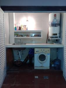 a kitchen with a sink and a washing machine at San Juan Santo Tome in Santo Tomé