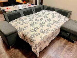 een bed in een kamer met 2 stoelen en een tafel bij Private spacious oversized suite with free parking in Kingston