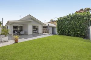 a house with a green lawn in front of it at Spacious 4-Bed House with Secure Parking in Brisbane