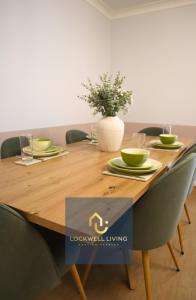 een houten tafel met stoelen en een vaas erop bij Chalfont Haven 