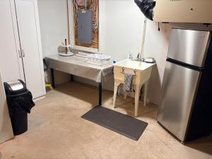 een keuken met een tafel, een wastafel en een koelkast bij Private spacious oversized suite with free parking in Kingston +23 foto's