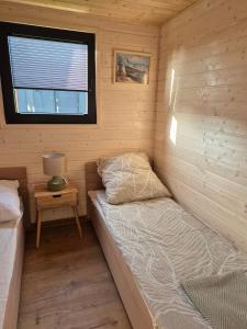 een kleine kamer met een bed in een hut bij Zakątek Dębki in Dębki