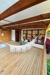 een veranda met een hangmat op een houten terras bij Cabañas Sentido Ancestral in Jardin