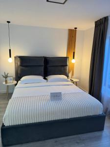 een slaapkamer met een groot bed met een zwart hoofdeinde bij RDT Guest House-Rai din Transilvania in Moieciu de Jos