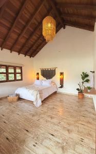 een slaapkamer met een groot bed en een kroonluchter bij Cabañas Sentido Ancestral in Jardin