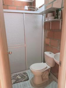 een badkamer met een douche, toilet en wastafel bij CasaJuan in Roldanillo