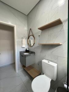 een witte badkamer met een toilet en een wastafel bij Casa com Piscina em Tamandaré in Tamandaré +15 foto's