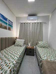 a bedroom with two twin beds and a window at Casa com Piscina em Tamandaré in Tamandaré