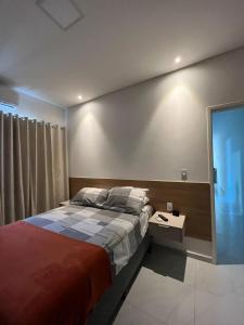 a bedroom with a large bed and a side table at Casa com Piscina em Tamandaré in Tamandaré