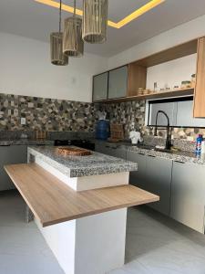 a kitchen with a counter top in the middle at Casa com Piscina em Tamandaré in Tamandaré