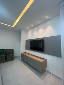 een woonkamer met een flatscreen-tv aan de muur bij Casa com Piscina em Tamandaré in Tamandaré