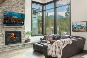 a living room with a leather couch and a fireplace at Evergreen Reserve in Winter Park +64 photos