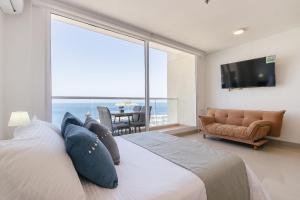 a bedroom with a large bed with a view of the ocean at Eira: Luxury and Serenity by the Sea in Santa Marta in El Prado