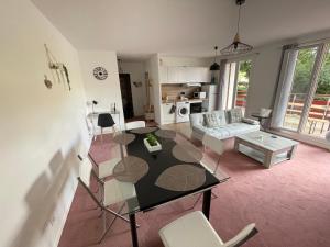 a living room with a glass table and chairs at Appartement Saint Genis Pouilly Cern in Saint-Genis-Pouilly