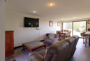 een woonkamer met een bank en een tafel bij Casa Pingueral Tomé in Concepción