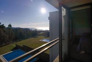 een balkon met uitzicht op een huis met een zwembad bij Casa Pingueral Tomé in Concepción