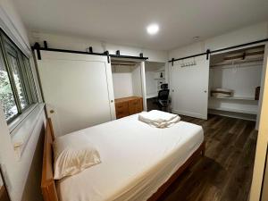 een slaapkamer met een bed met witte lakens en een raam bij Ensuite Private Room in Austin