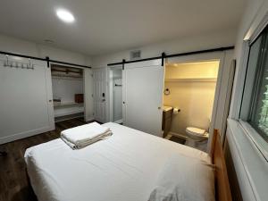 een slaapkamer met een wit bed en een toilet bij Ensuite Private Room in Austin