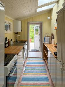 a kitchen with a colorful rug on the floor at Summerhouse Close To Nature And Beach in Rørvig
