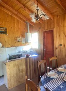 une cuisine avec une table et une salle à manger dans l'établissement Cabañas los Jardines de Lican ray, à Licán Ray 2 autres photos