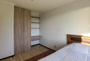 een slaapkamer met een bed en een houten kast bij Casa Pingueral Tomé in Concepción