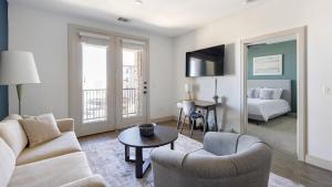 een woonkamer met een bank en een kamer met een bed bij Landing Stunning 2BD Courtyard Gym in Denton +25 foto's