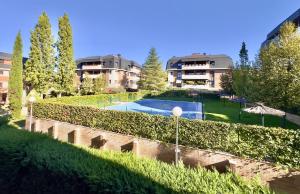 een gebouw met een zwembad in een tuin bij Golf Apartment in Majadahonda