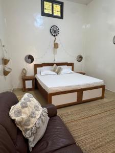 a bedroom with a bed and a couch and a clock on the wall at Maison Diop in Ziguinchor