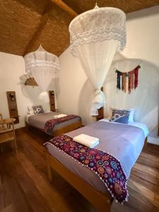 ein Schlafzimmer mit zwei Betten und einem Kronleuchter in der Unterkunft Eco Terra Lodge in Santa María