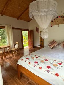 ein Schlafzimmer mit Bett, Tisch und Fenster in der Unterkunft Eco Terra Lodge in Santa María