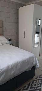 a bedroom with a white bed and a window at Grace Villas 30 in East London