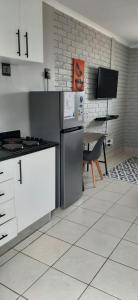 a kitchen with white appliances and a table with a television at Grace Villas 30 in East London