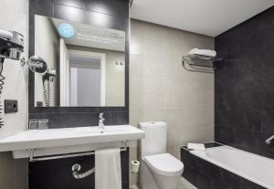 a bathroom with a sink, toilet and bathtub at Ilunion Suites Madrid in Madrid