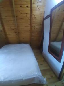 een slaapkamer met een wit bed in een houten kamer bij Alpinas El Chusmo 2 in Villa Ciudad Parque