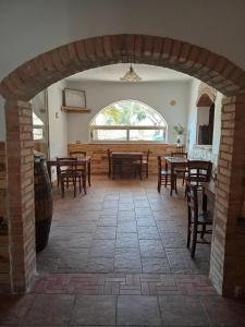 a dining room with tables and chairs and an archway at Casa Presenza in Santa Elisabetta +27 photos
