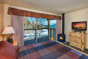 a living room with a fireplace and a television with a view at Tahoe Lakeshore Lodge & Spa in South Lake Tahoe