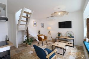 a living room with a spiral staircase and a tv at Les Gites de Mael et Rose in Plougasnou