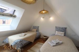 une chambre mansardée avec deux lits et une fenêtre dans l'établissement Les Gites de Mael et Rose, à Plougasnou