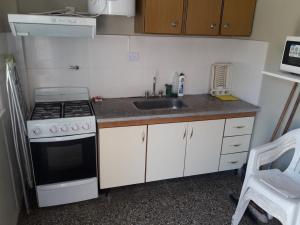 een kleine keuken met een fornuis en een spoelbak bij Mary in Costa Azul